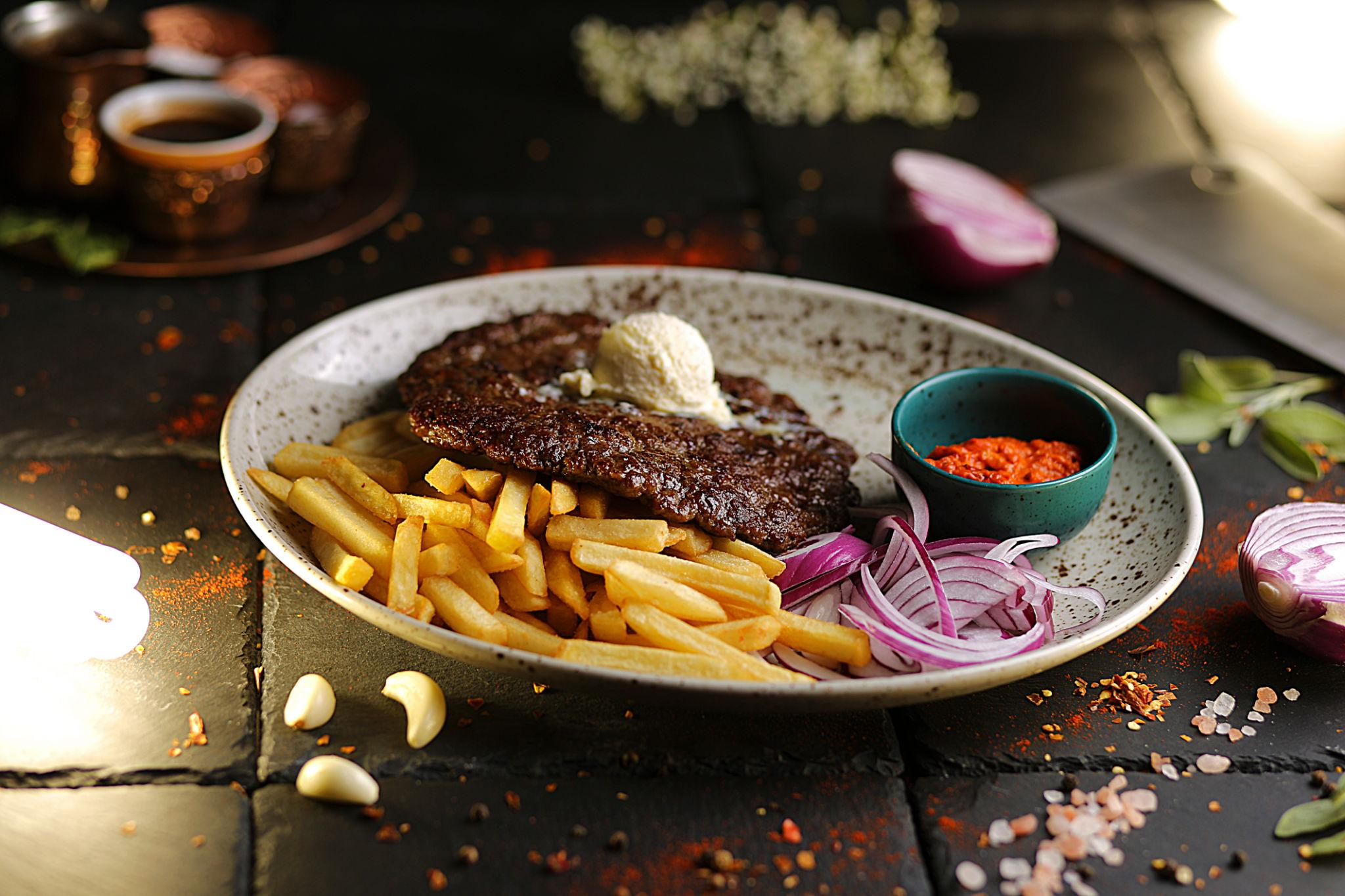 Grilled čevapčiči with fries, red onion and ajvar